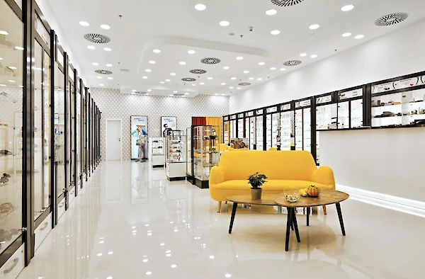 Interiér optiky, velký žlutý gauč uprostřed