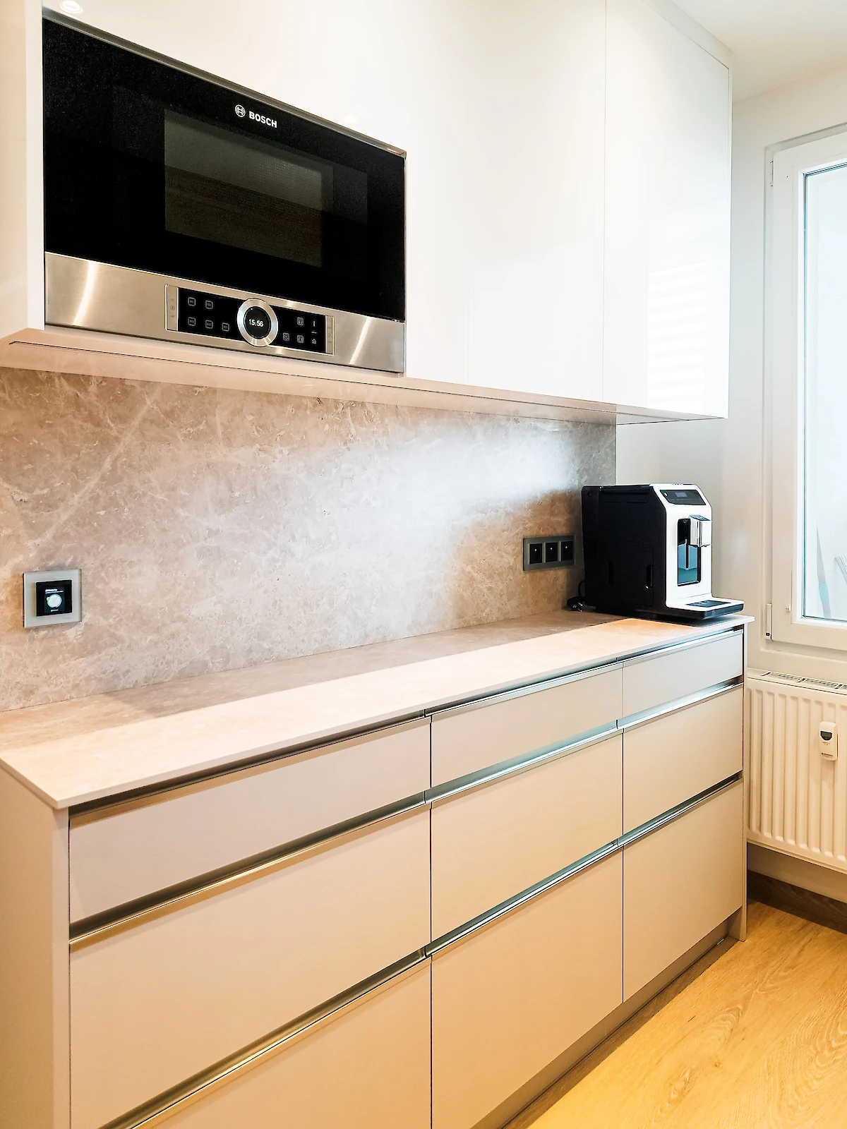 Pohled na kuchyňské skříňky, na lince kávovar, nahoře zabudovaná mikrovlnná trouba