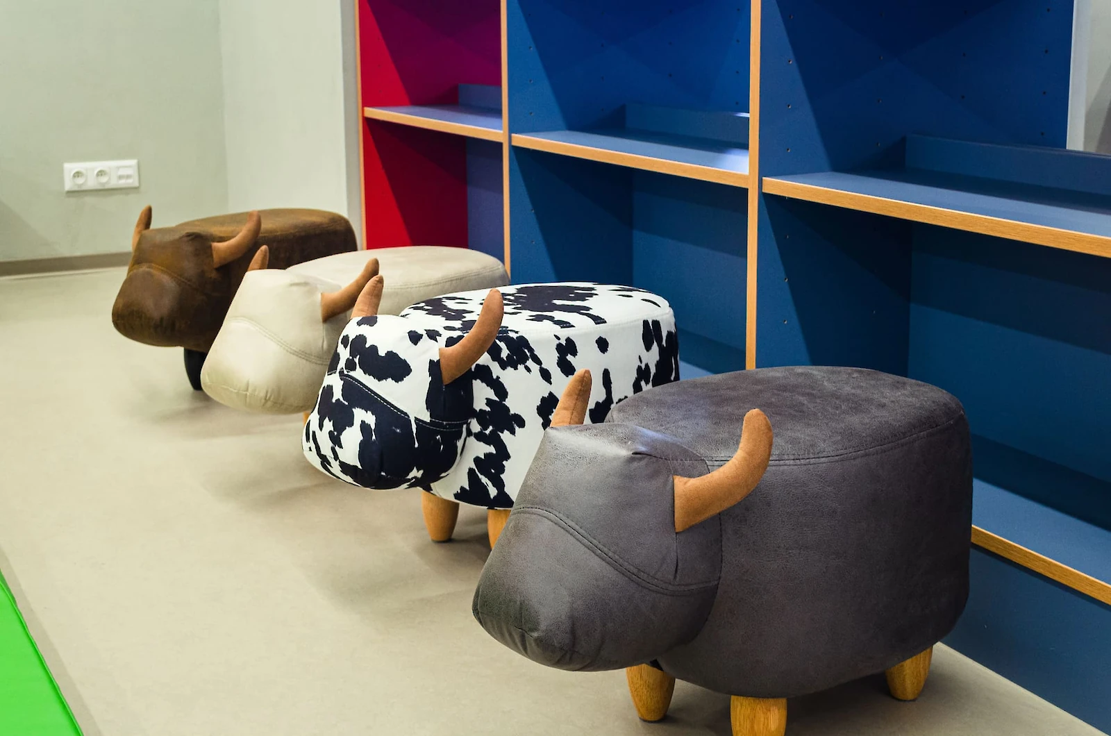 Stoličky ve tvaru zvířat s barevnými dekory, modré a červené regály