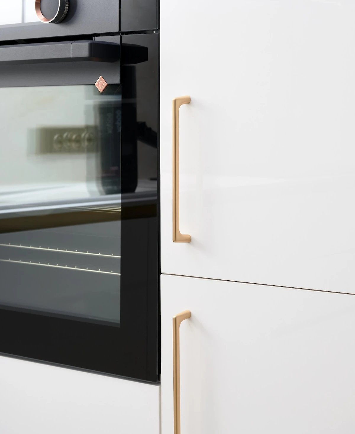 Kuchyňská dvířka se zlatými úchyty a spotřebiči