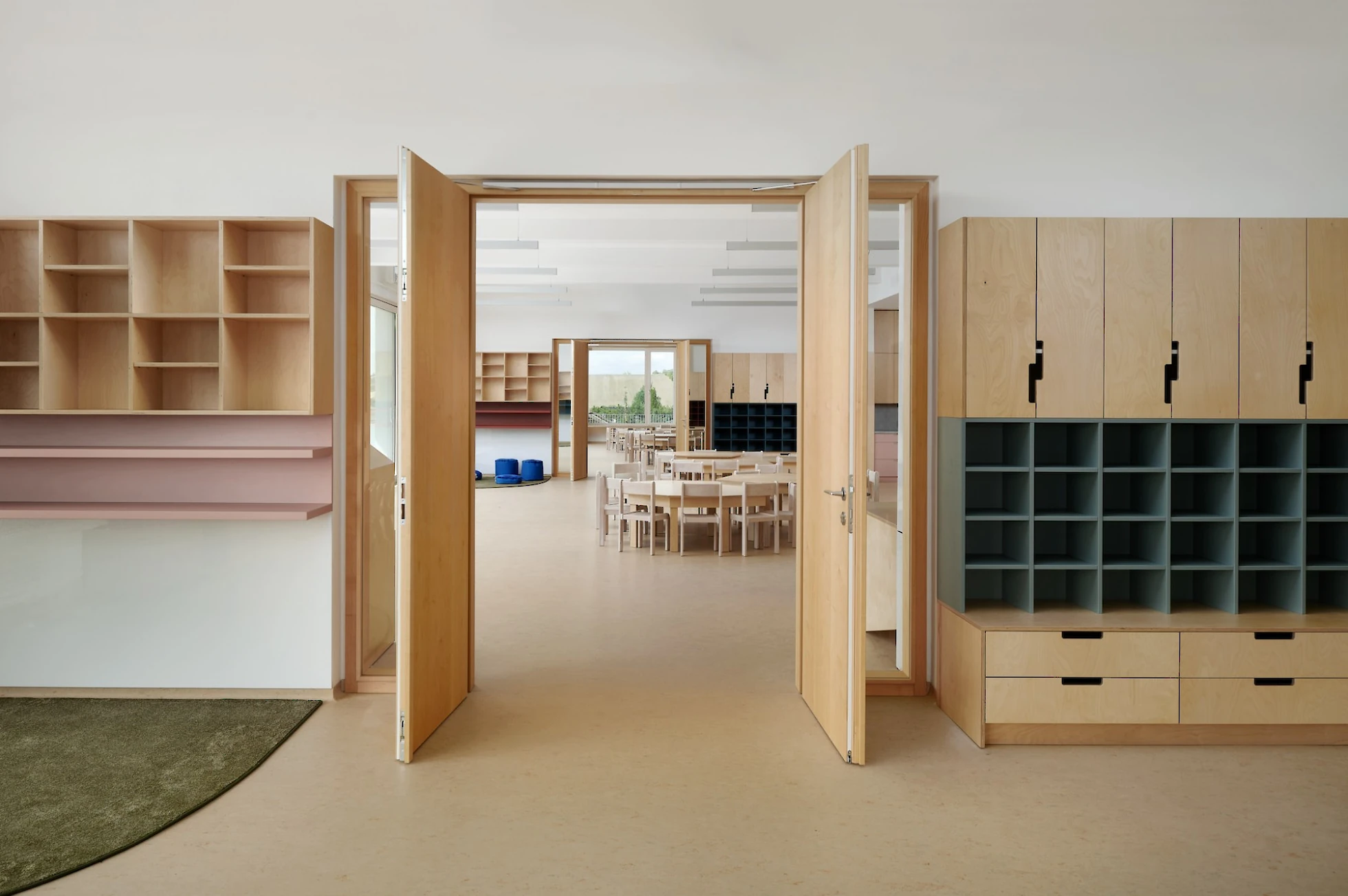 Vstup do dětské třídy se stolky a židličkami, úložné prostory